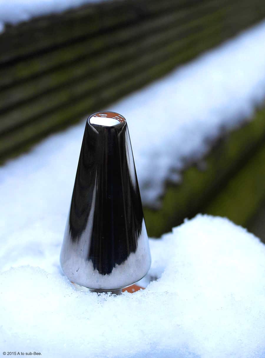 A butt plug nestled in the snow showing winter reflections