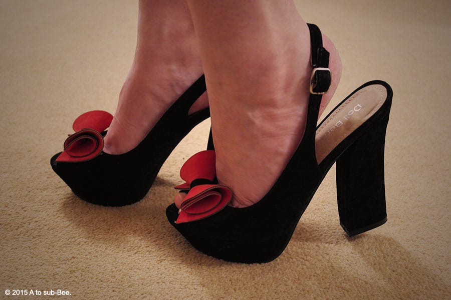 SHowing off my kind of porn...some pretty black high heeled shoes with a red bow