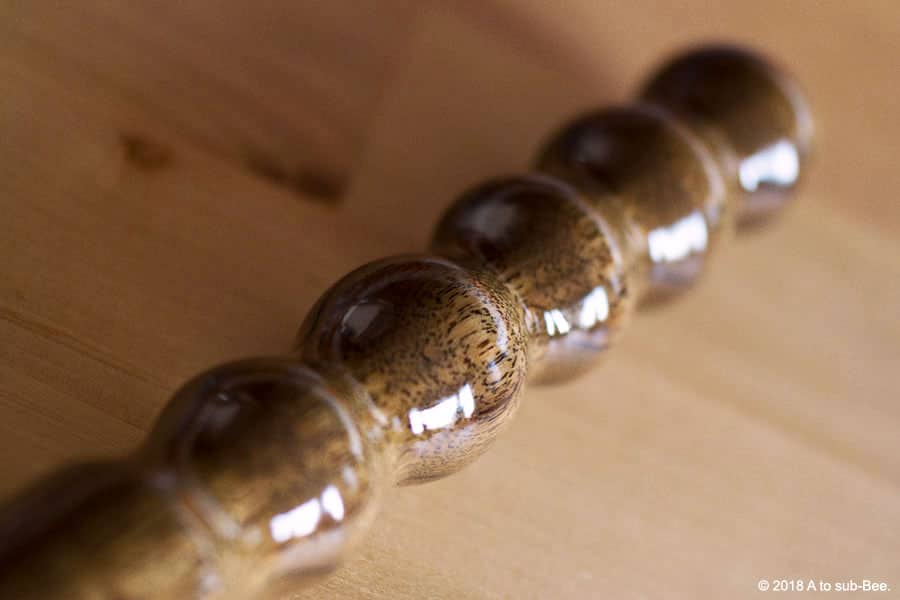 An image of a wooden dildo made up of lots of bumps for texture