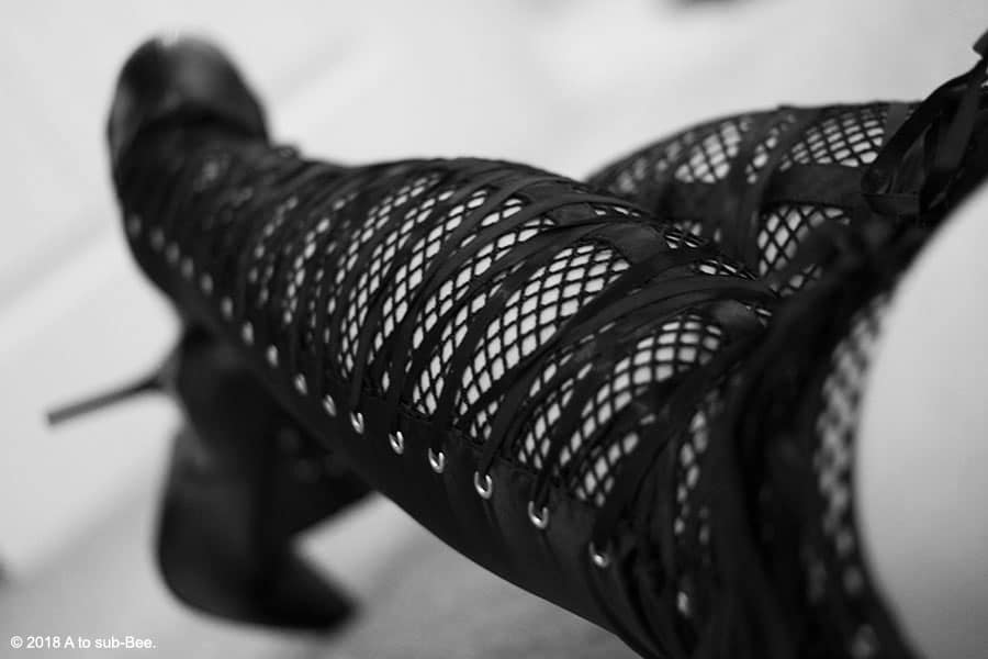 A look down the back of Bee's legs at their lace backed knee high boots tied up with ribbon
