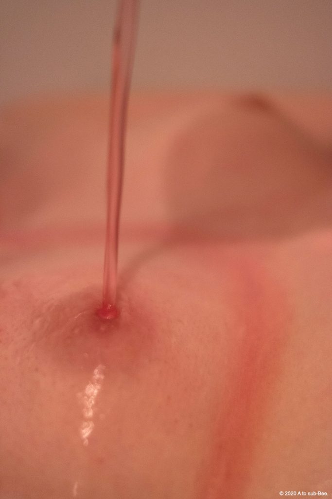 Bee having slippery pink goo poured on their nipple