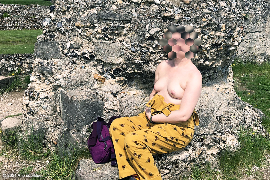 Bee sat among ruins with their breasts exposed