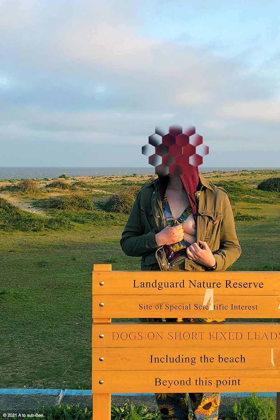 Bee flashing theor tits next to a nature reserve sign